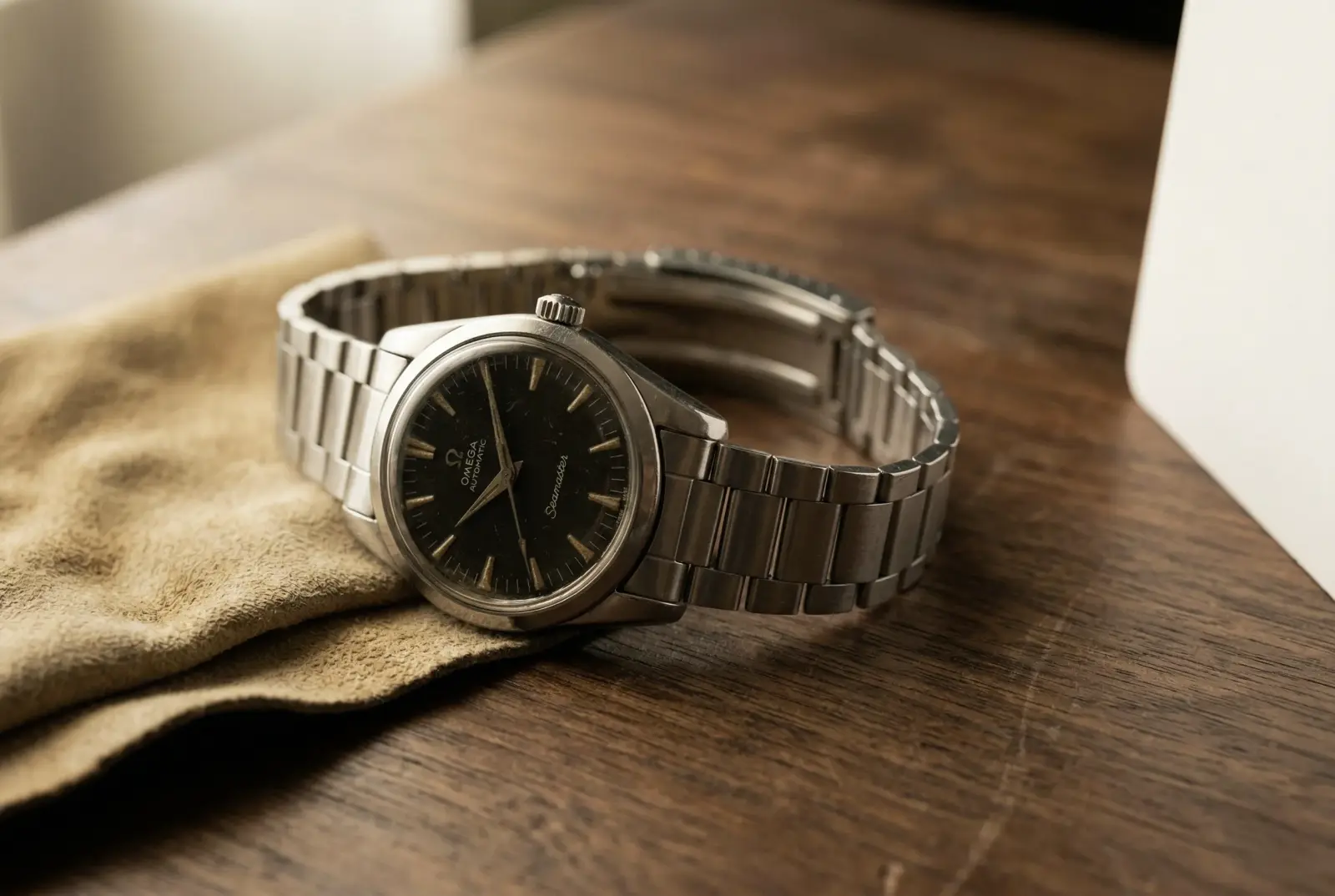 Vintage Omega Seamaster wristwatch on a walnut surface